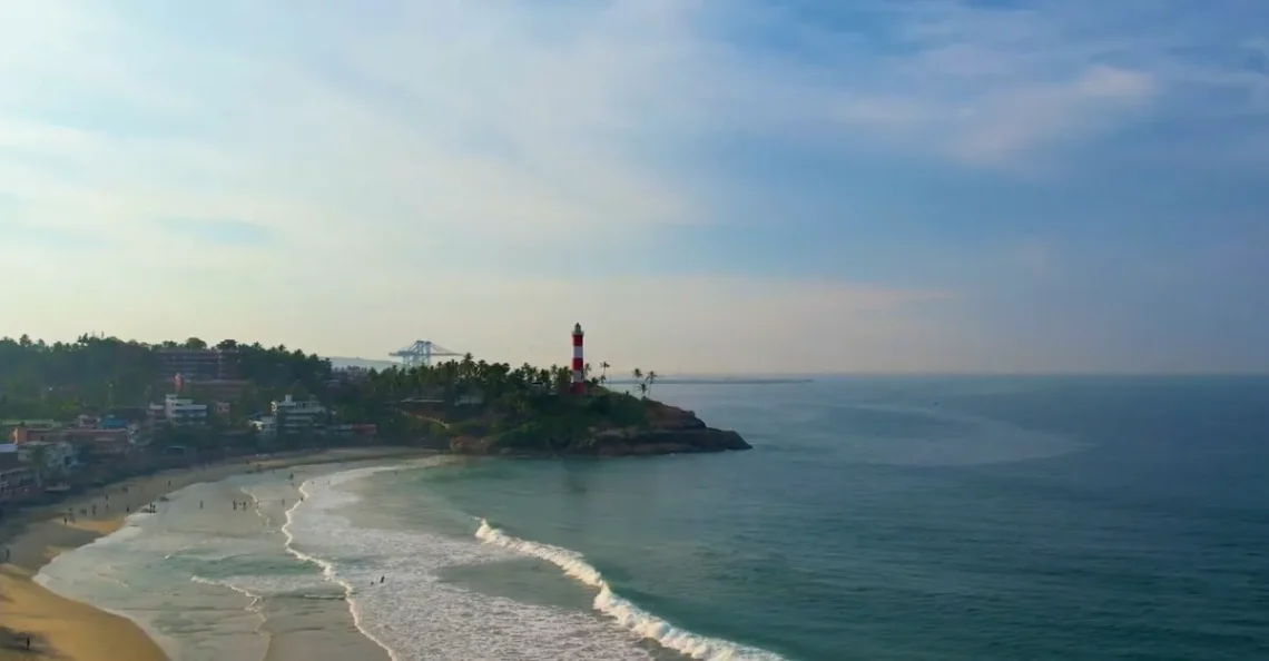 Kovalam Beach with a lighthouse and a house, capturing the essence of why do I feel so relaxed at the beach.