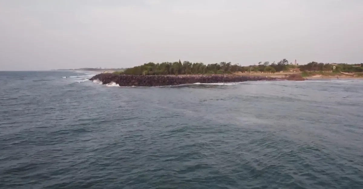 Overhead shot of Mahabalipuram Beach, featuring rocky shores and a small island, inspiring thoughts on beach relaxation.