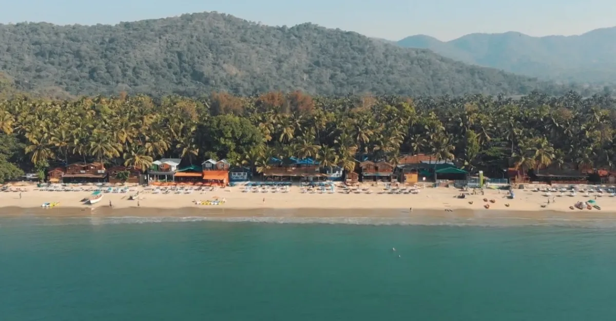 Overhead shot of Palolem Beach, highlighting the calm waves and vibrant resort, making you wonder why you feel so relaxed at the beach