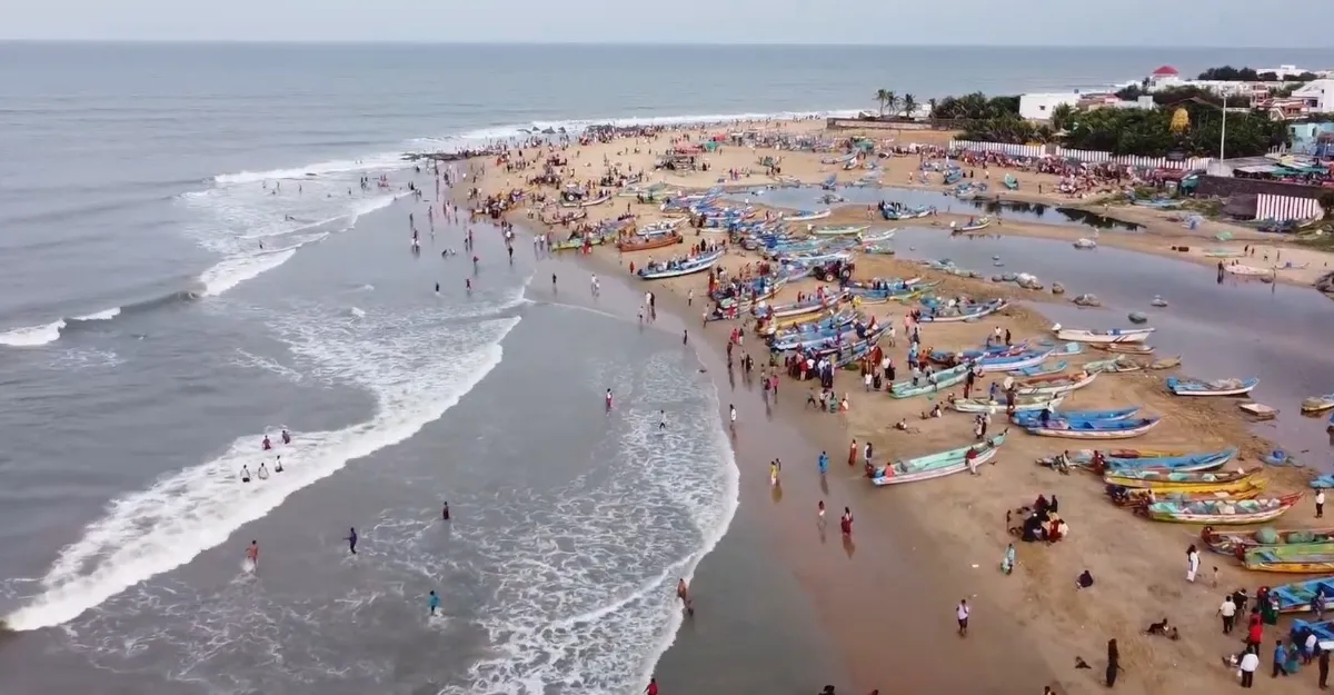 Aerial image of Kovalam Beach, Kerala, highlighting a picturesque beach with an array of boats on the tranquil waters.